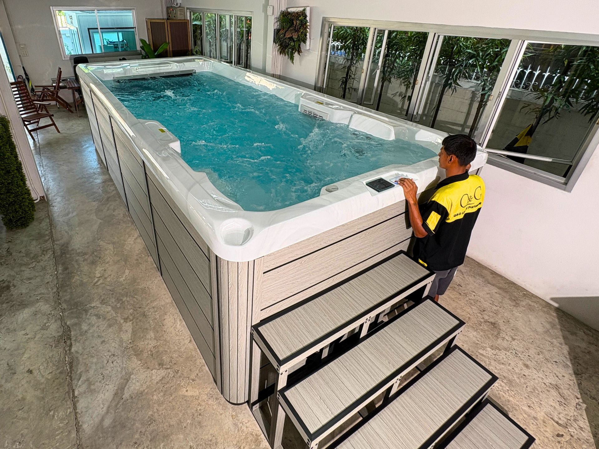 Swim spa filled with water and running counter-current swim system, supported by a durable galvanized steel frame.