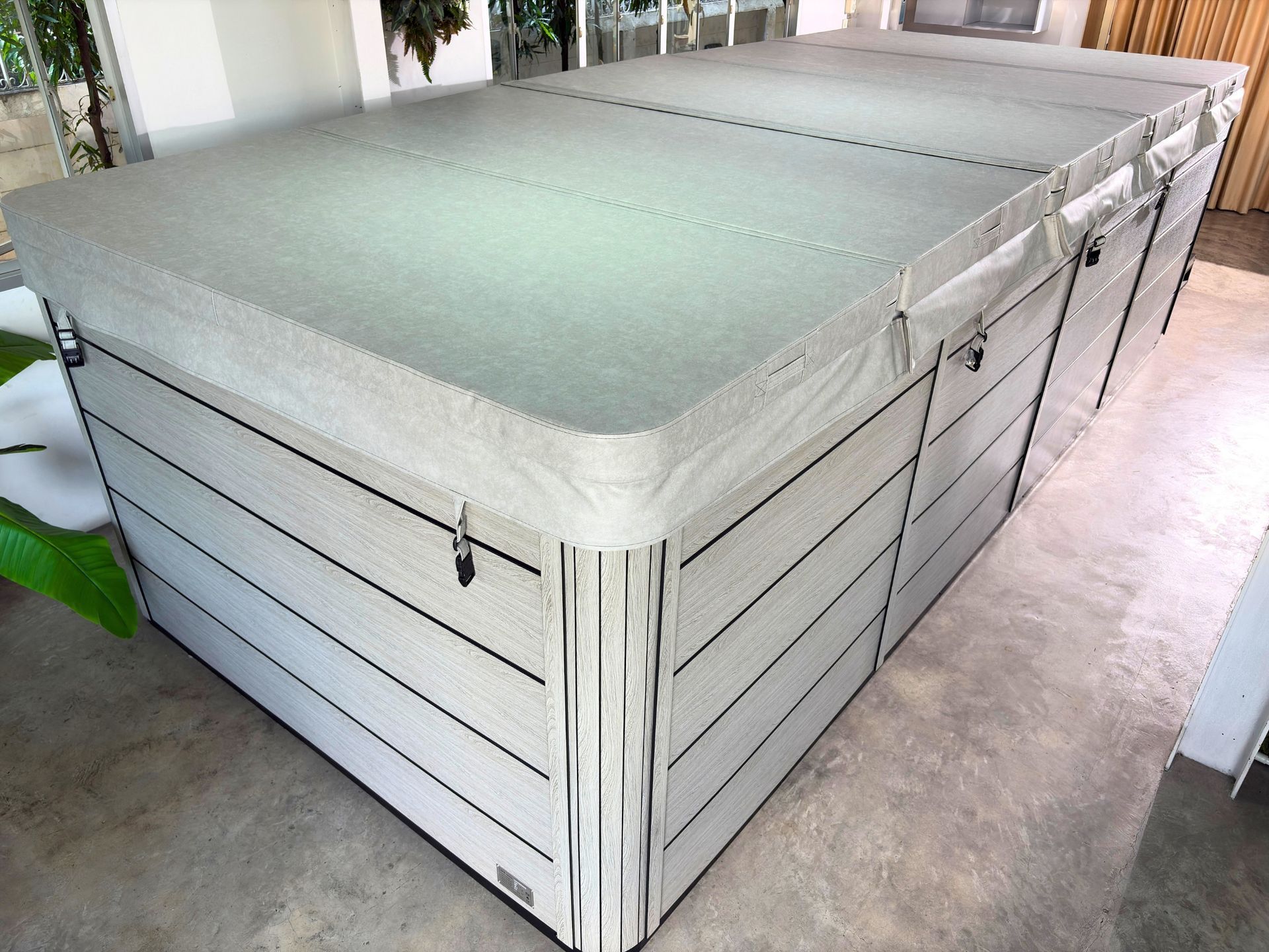 Swim spa fully covered with insulated hard cover for heat retention, built on a corrosion-resistant galvanized steel frame.