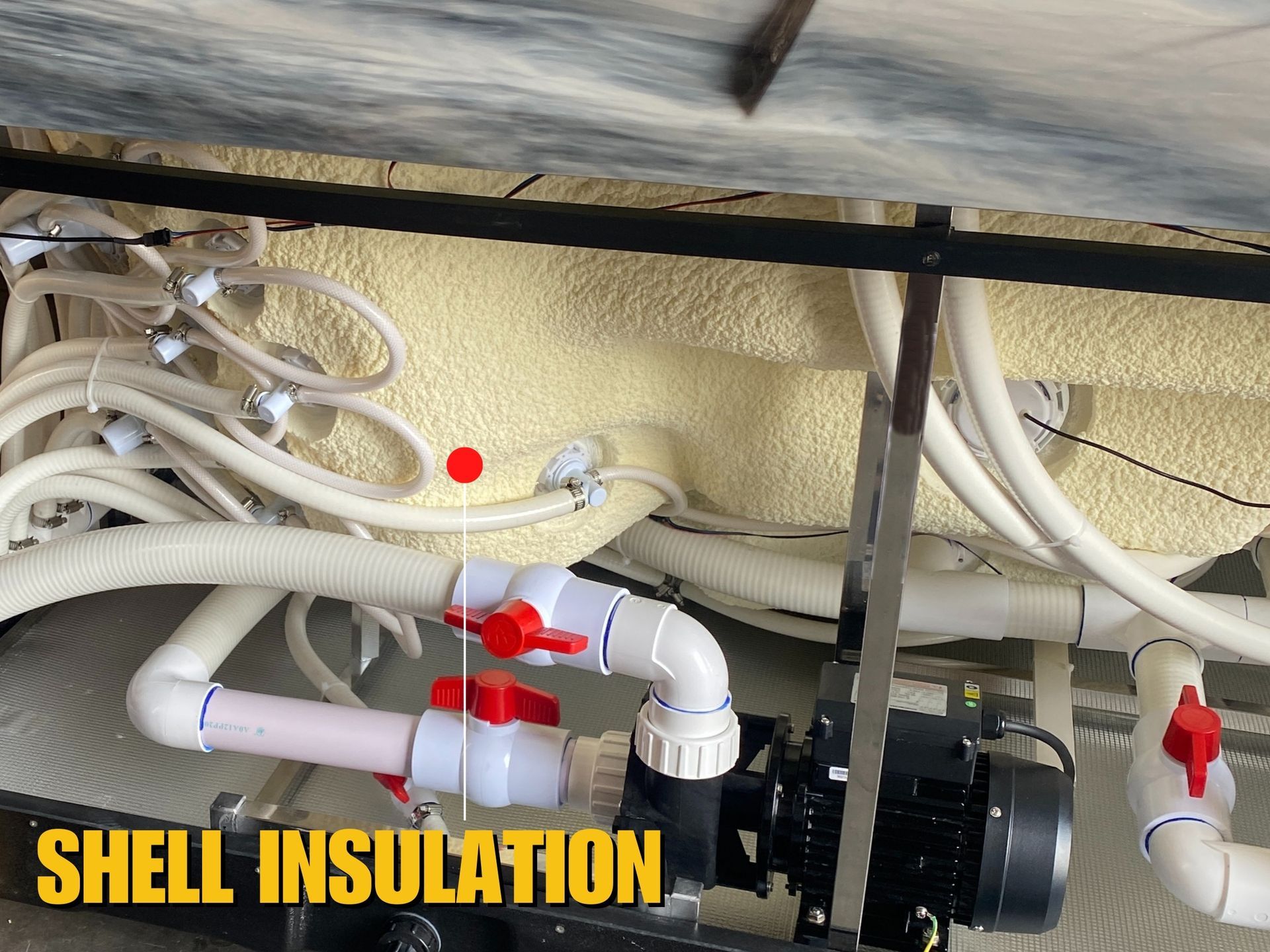 ภาพโครงสร้างภายในอ่างน้ำร้อนแสดงชั้นฉนวนโฟมรอบตัวอ่าง ช่วยกักเก็บความร้อนของน้ำอุ่นภายใน ลดการสูญเสียความร้อน และช่วยประหยัดค่าไฟฟ้า พร้อมระบบท่อและปั๊มที่ติดตั้งอย่างเป็นระเบียบใต้โครงสร้างอ่าง