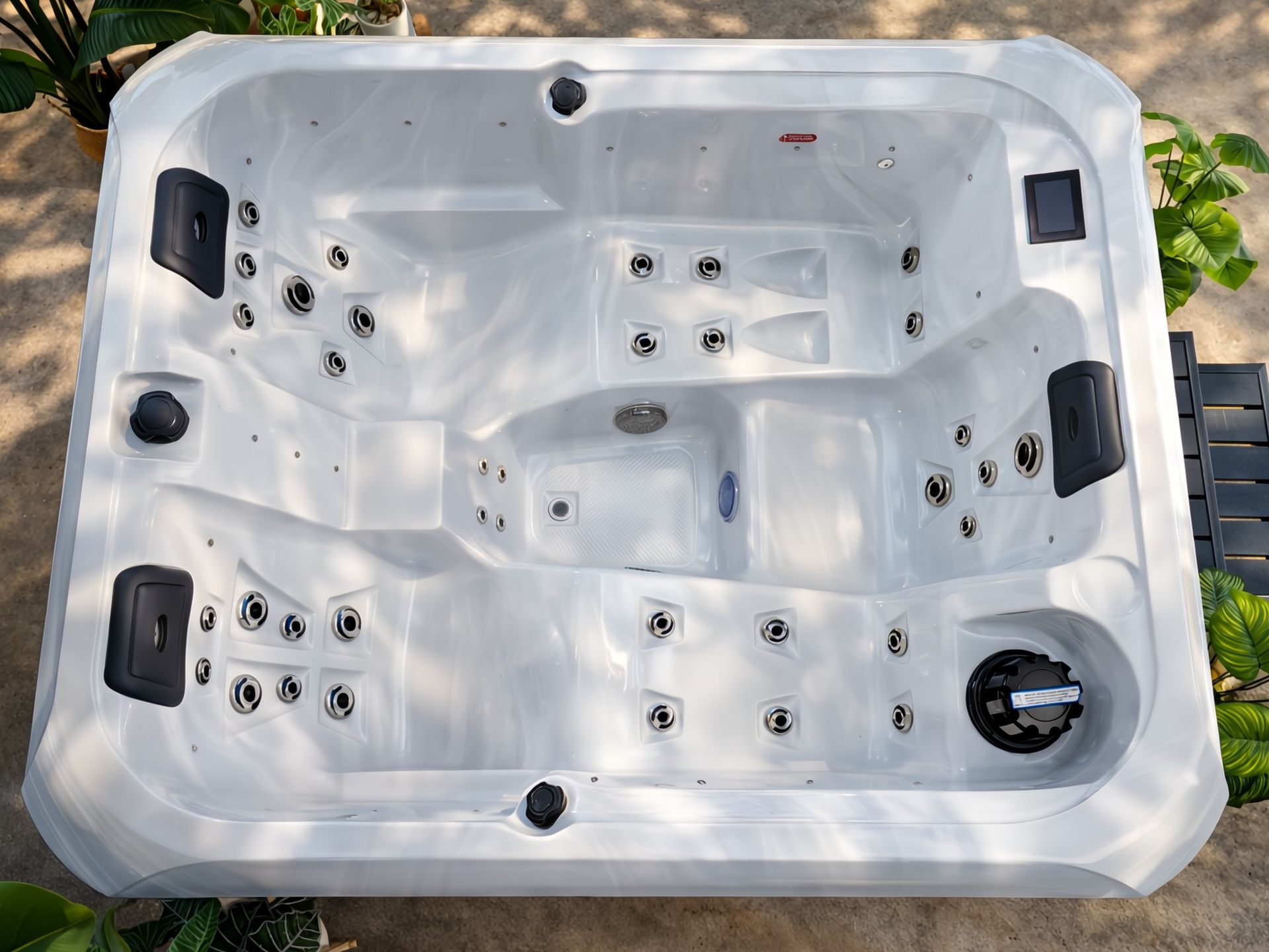 ภาพมุมสูงของอ่างน้ำร้อนสปากลางแจ้ง แสดงการออกแบบพื้นที่ใช้สอยภายในอ่างอย่างชัดเจน พร้อมที่นั่งหลายระดับ ระบบเจ็ทนวดน้ำรอบทิศทาง และตำแหน่งวางอุปกรณ์ควบคุม เหมาะสำหรับผู้ที่กำลังมองหาอ่างจากุซซี่สำหรับบ้านหรือวิลล่า