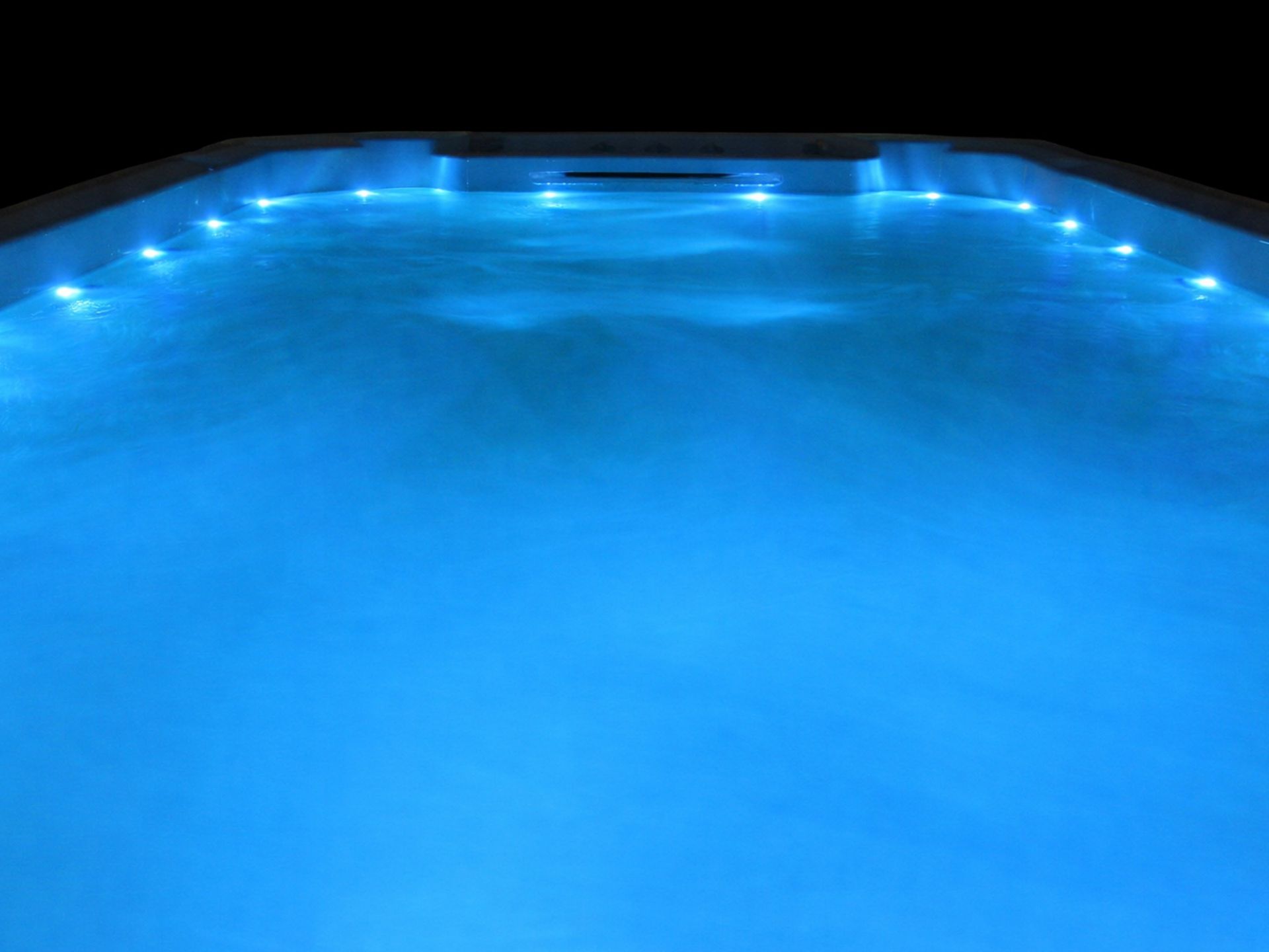 สระว่ายน้ำสปาติดตั้งกลางแจ้ง น้ำใสสีฟ้า พร้อมระบบไฟ LED ใต้น้ำ สร้างบรรยากาศผ่อนคลาย เหมาะสำหรับว่ายน้ำ ออกกำลังกาย และพักผ่อนภายในบ้าน