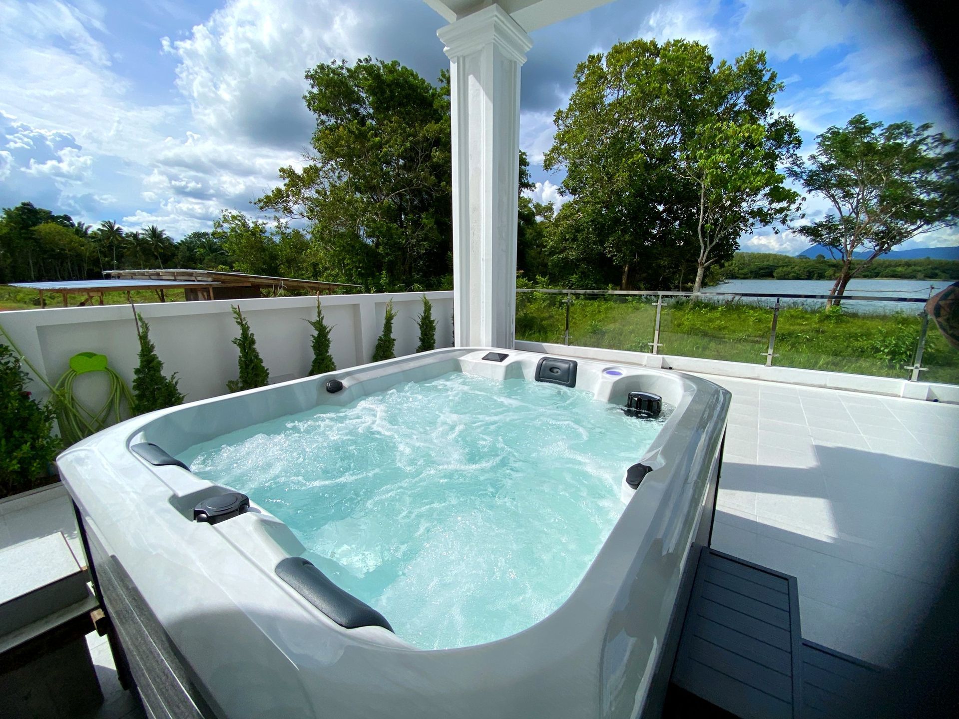 Oceanfront hot tub on a modern terrace with bubbling water and tropical view.