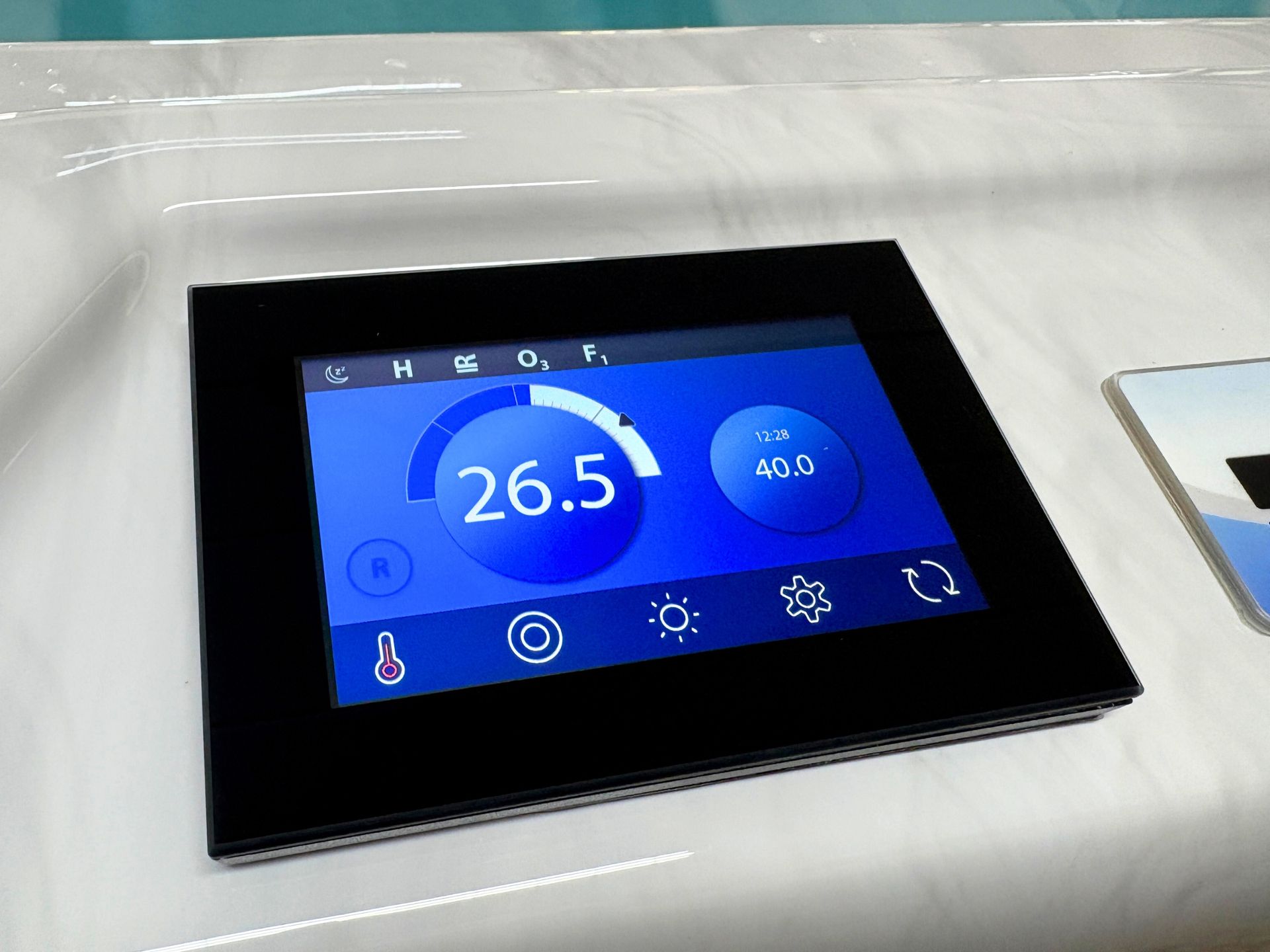 Hot tub touchscreen showing current water temperature and set temperature with control icons.