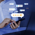 Person using a smartphone with floating star ratings and review chat icons above the screen