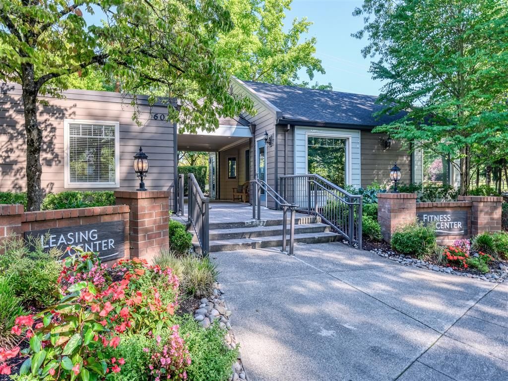 Exterior view of a multifamily community entrance with Leasing Center and Fitness Center signs.