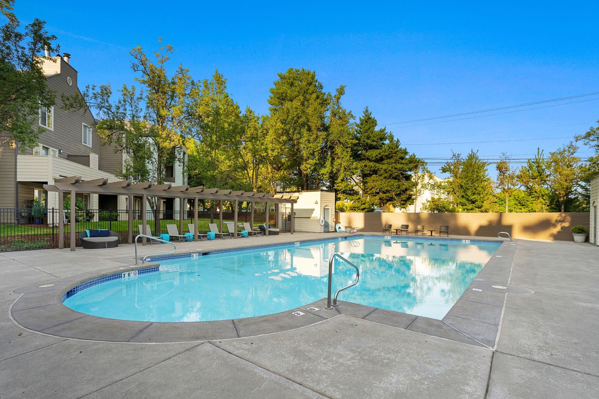 Outdoor communal courtyard with seating, yellow-striped umbrellas, and string lights.
