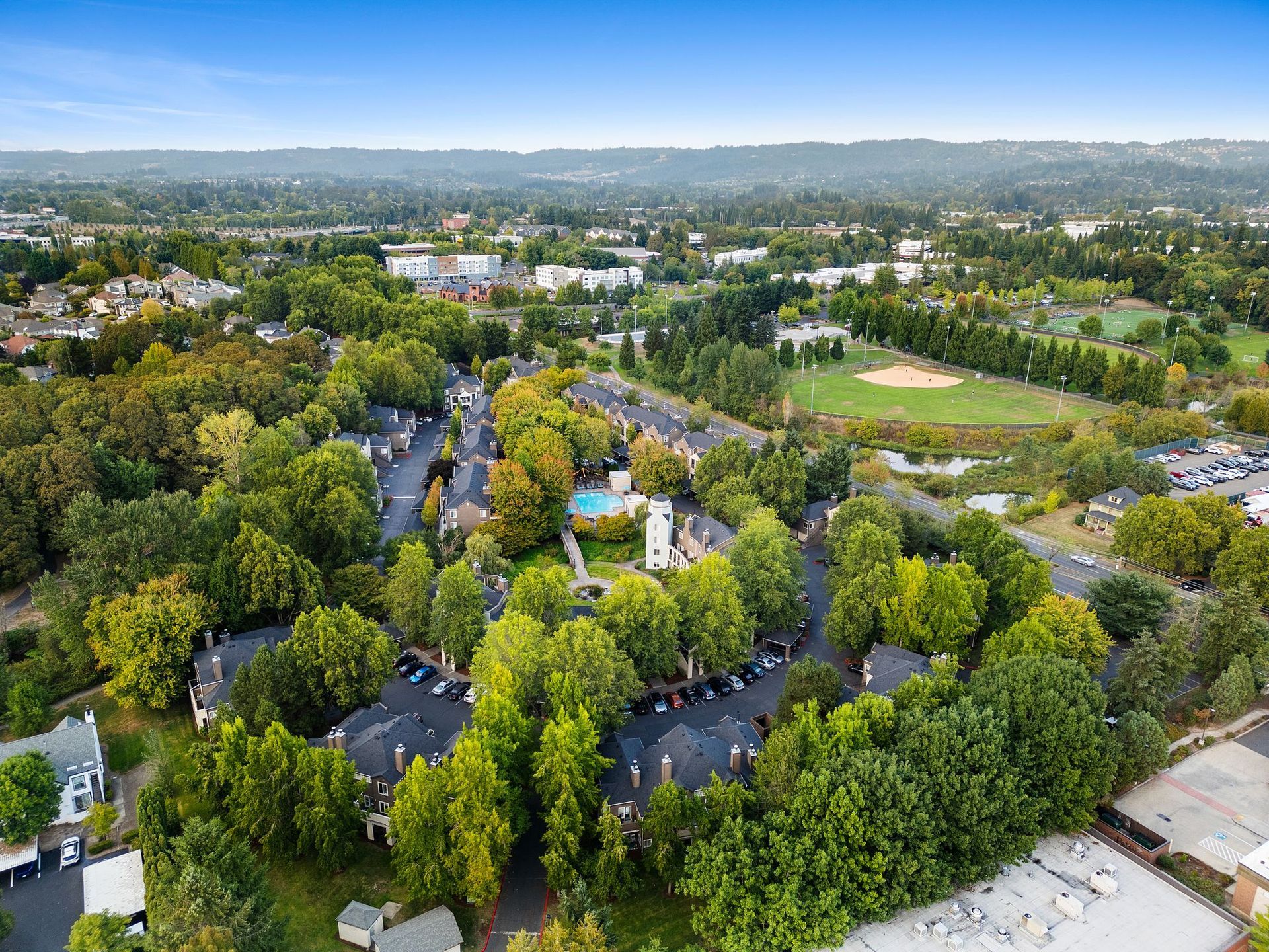 Aerial view of a circular apartment building with a central courtyard and surrounding trees.