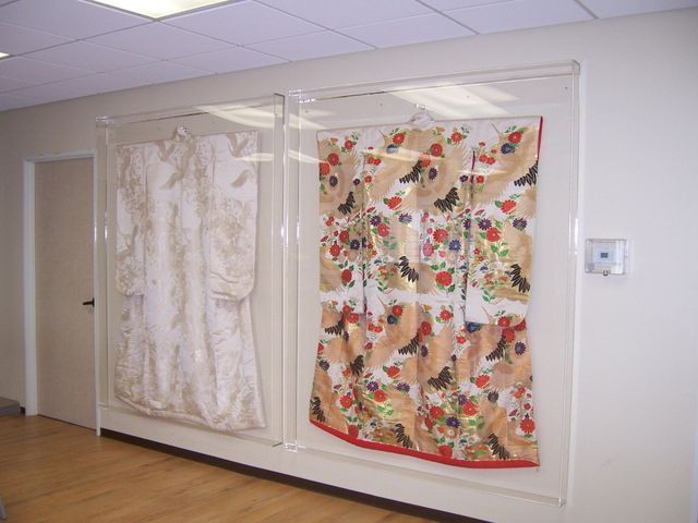 Two quilts are hanging on a wall in a hallway