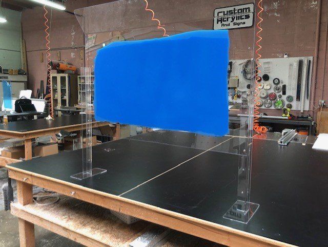 A blue plastic shield is sitting on top of a wooden table.