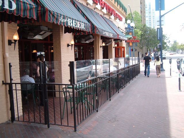 People sitting outside of a restaurant that says beer