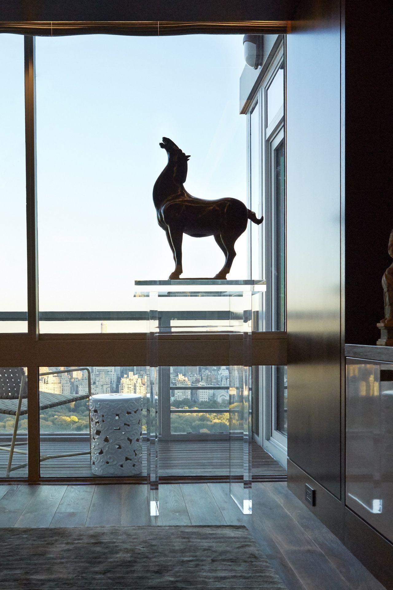 A statue of a horse is standing in front of a window