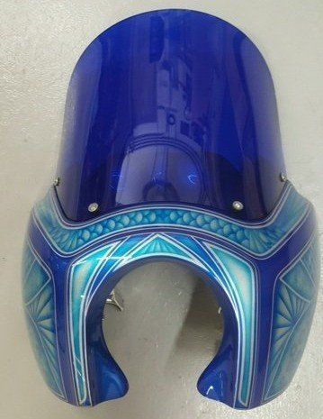 A blue motorcycle windshield with a geometric design on it