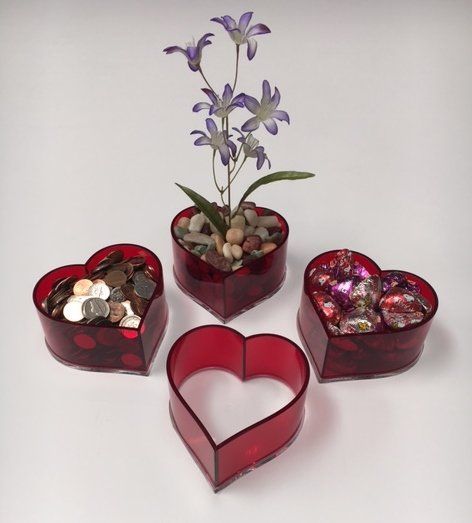 Four heart shaped containers filled with coins and flowers