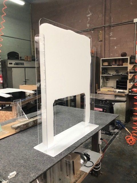 A clear acrylic shield is sitting on top of a table.