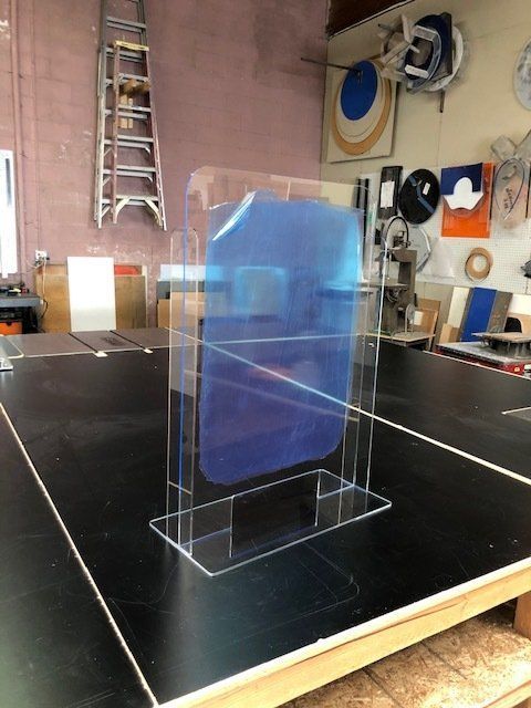 A clear acrylic box with a blue item inside of it