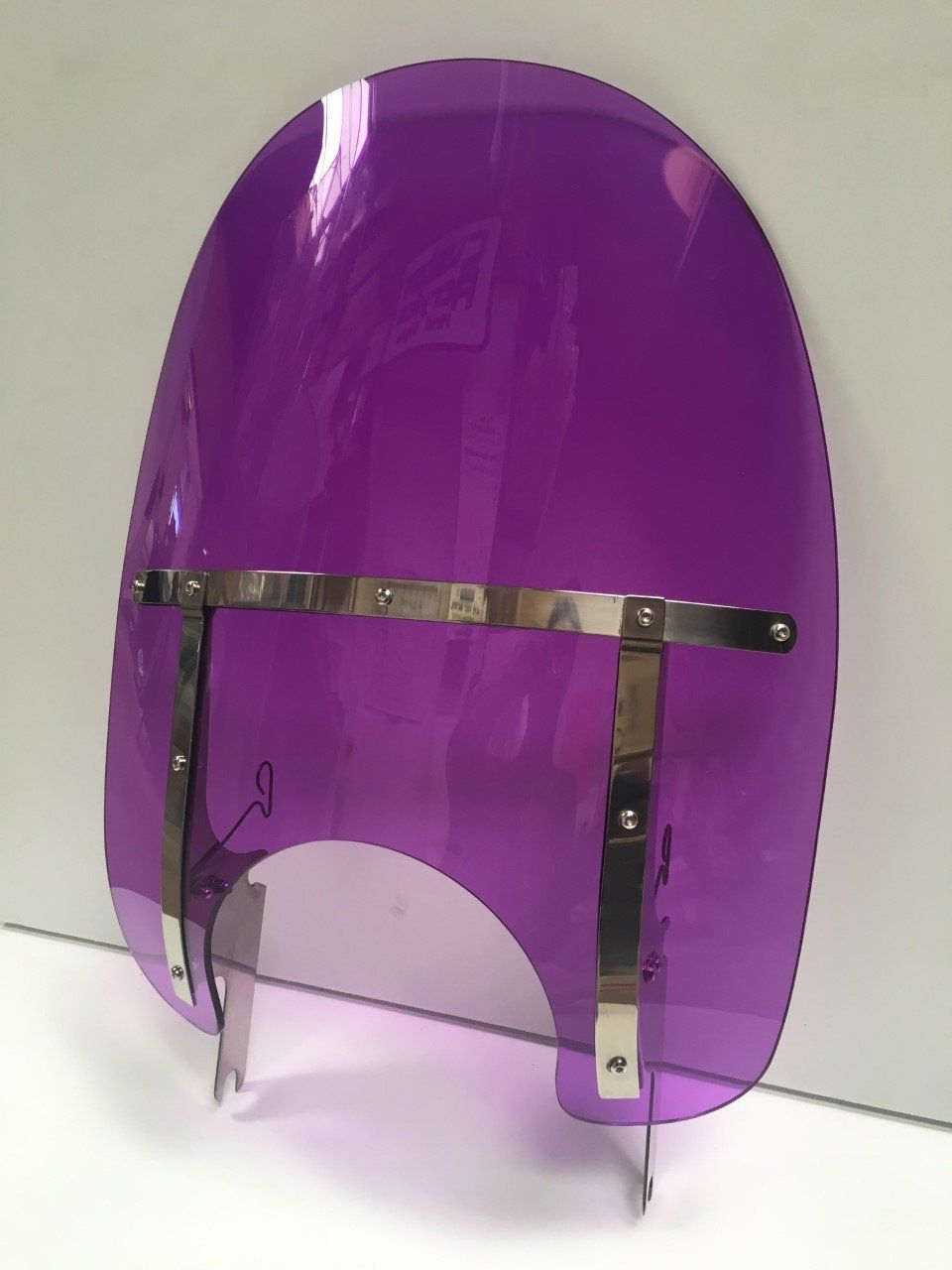 A purple windshield is sitting on a white surface