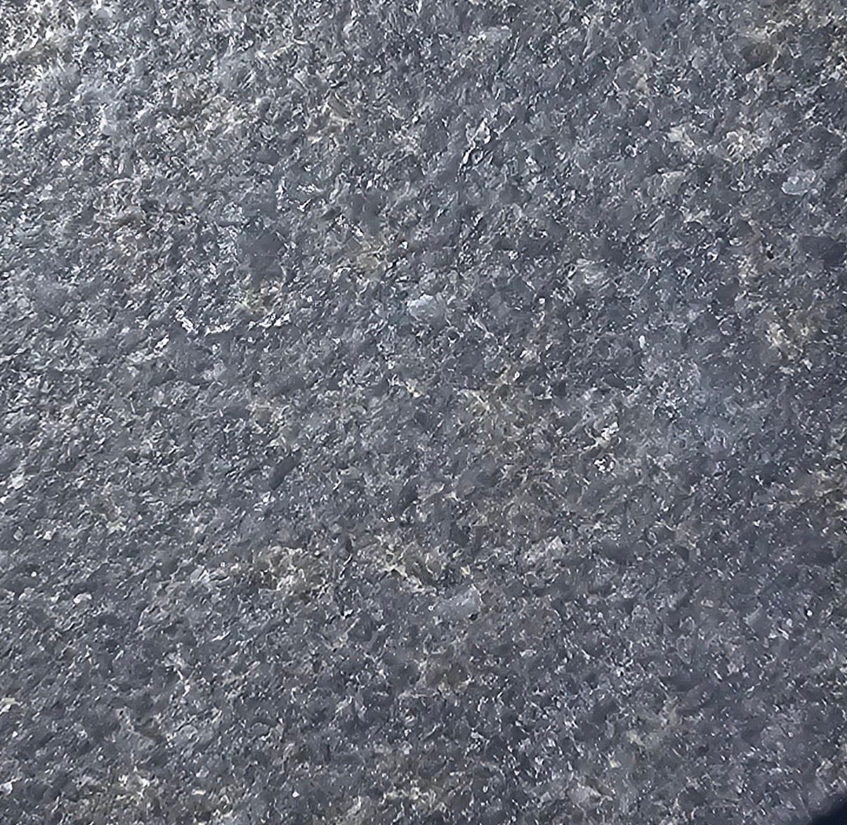 A close up of a gray surface with a lot of small stones on it.