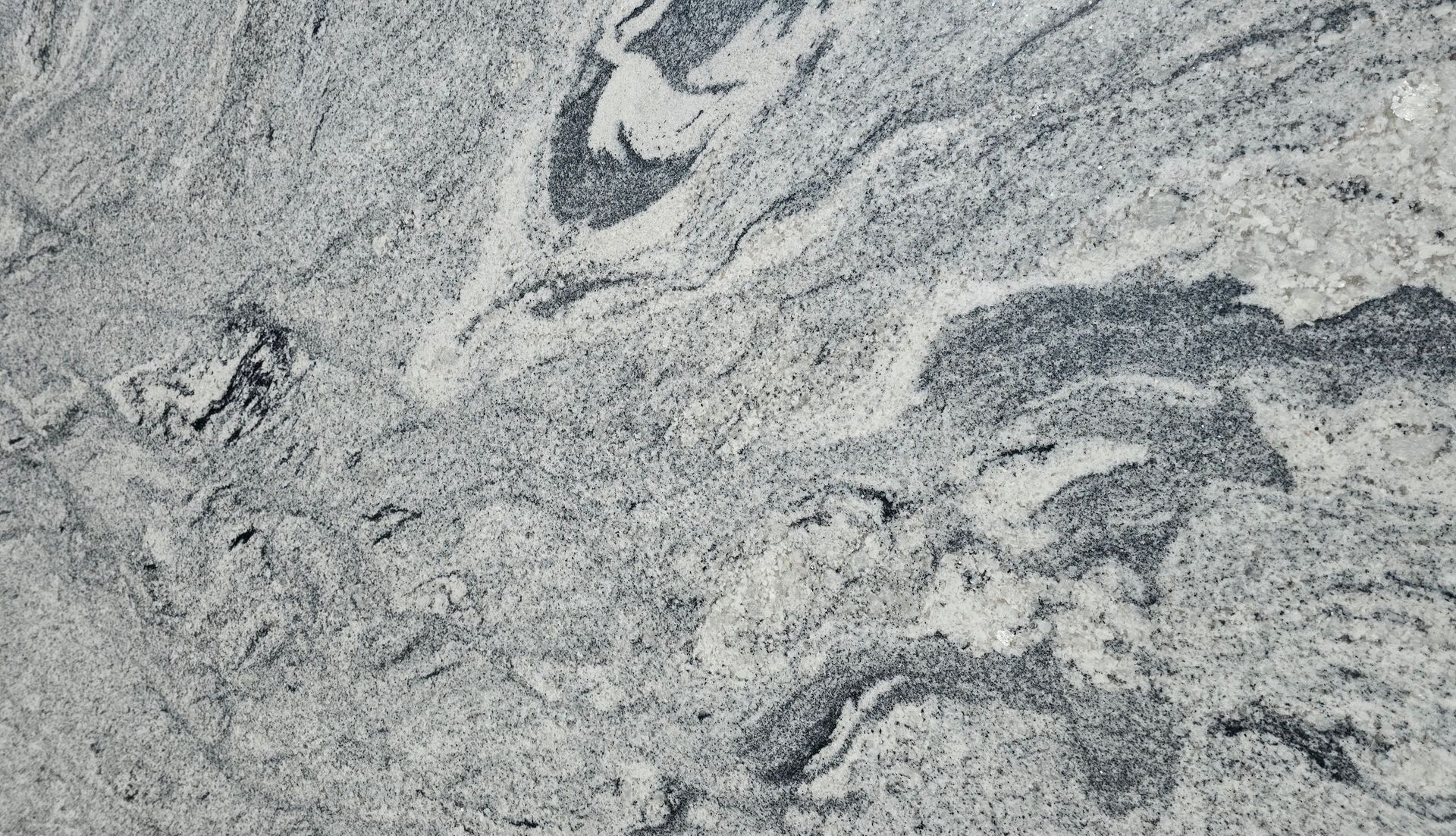 A close up of a granite counter top with a gray and white marble texture.
