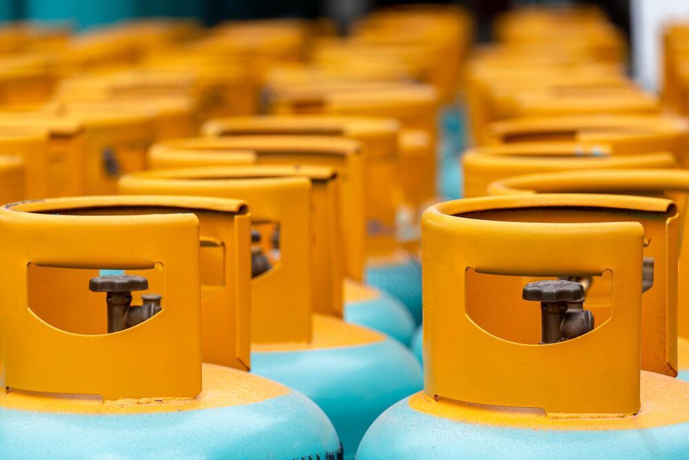 Rows of Yellow Propane Tanks, Teal Base, Focus on Valves, Shallow Depth of Field — Kuranda Gas & Supplies In Smithfield, QLD