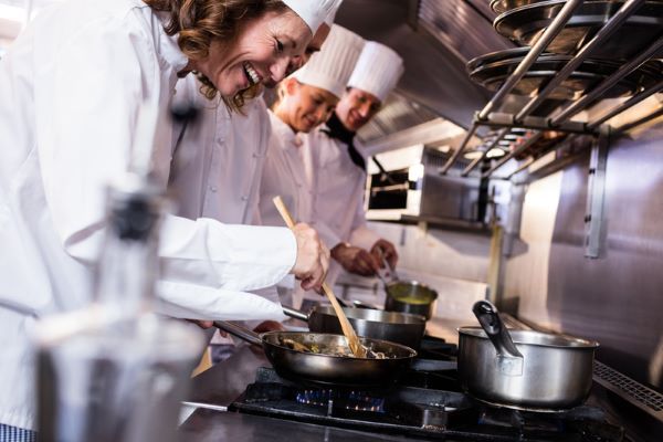 Chefs in White Uniforms Cook in A Restaurant Kitchen, Stirring Food in Pans Over a Stove — Kuranda Gas & Supplies In Koah, QLD