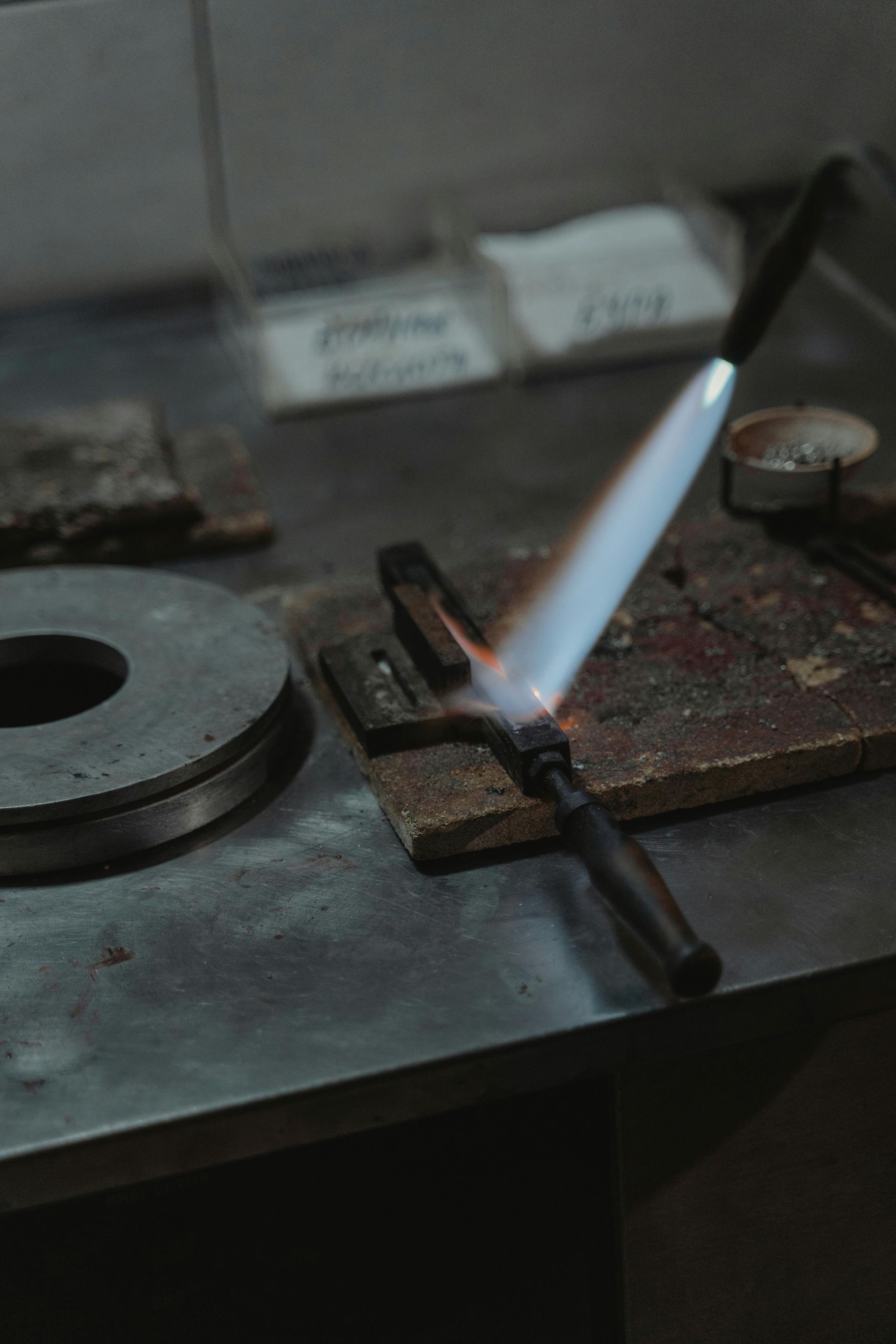 A Blowtorch Flames onto Metal Piece on A Workbench — Kuranda Gas & Supplies In Koah, QLD