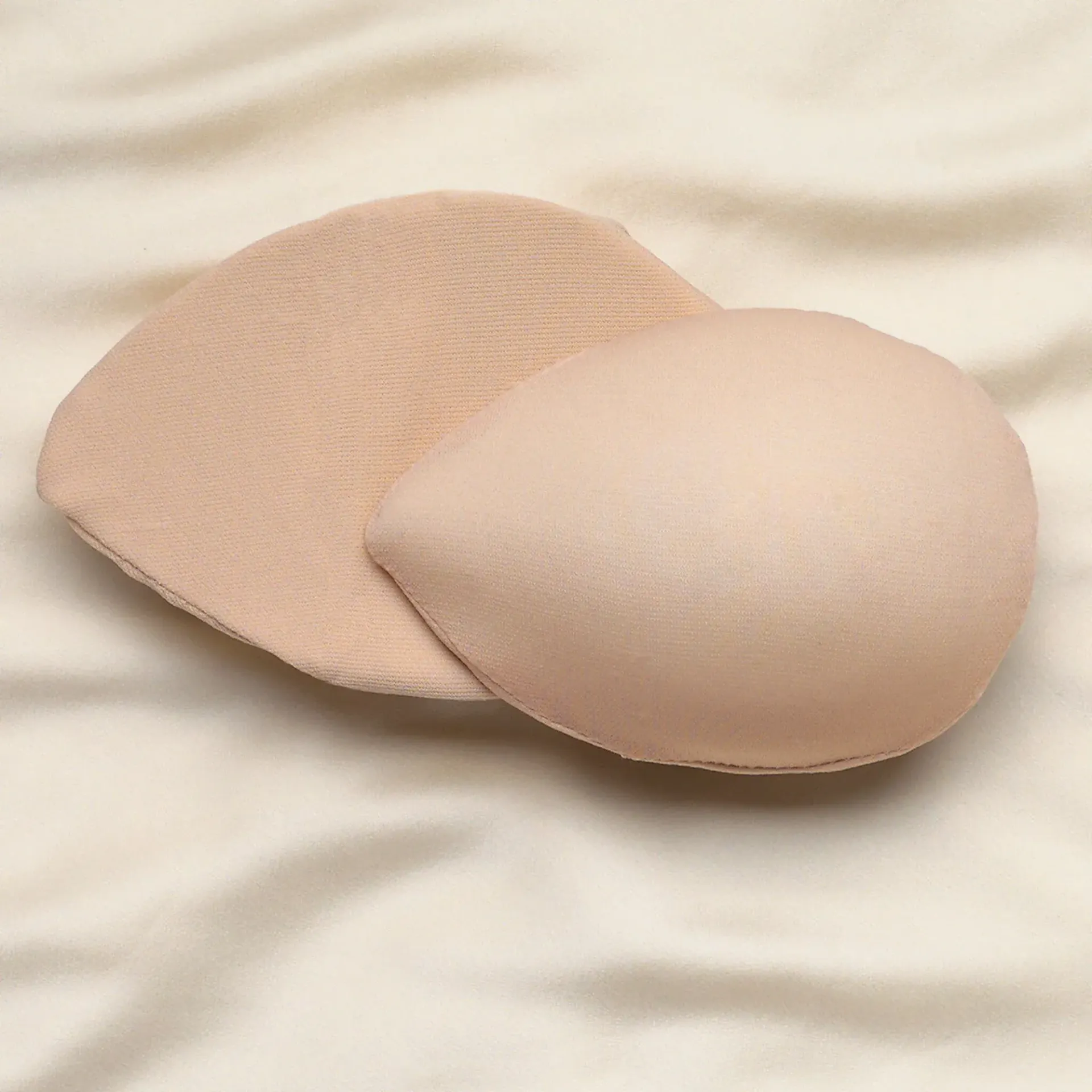 a pair of breast pads are sitting on a bed .