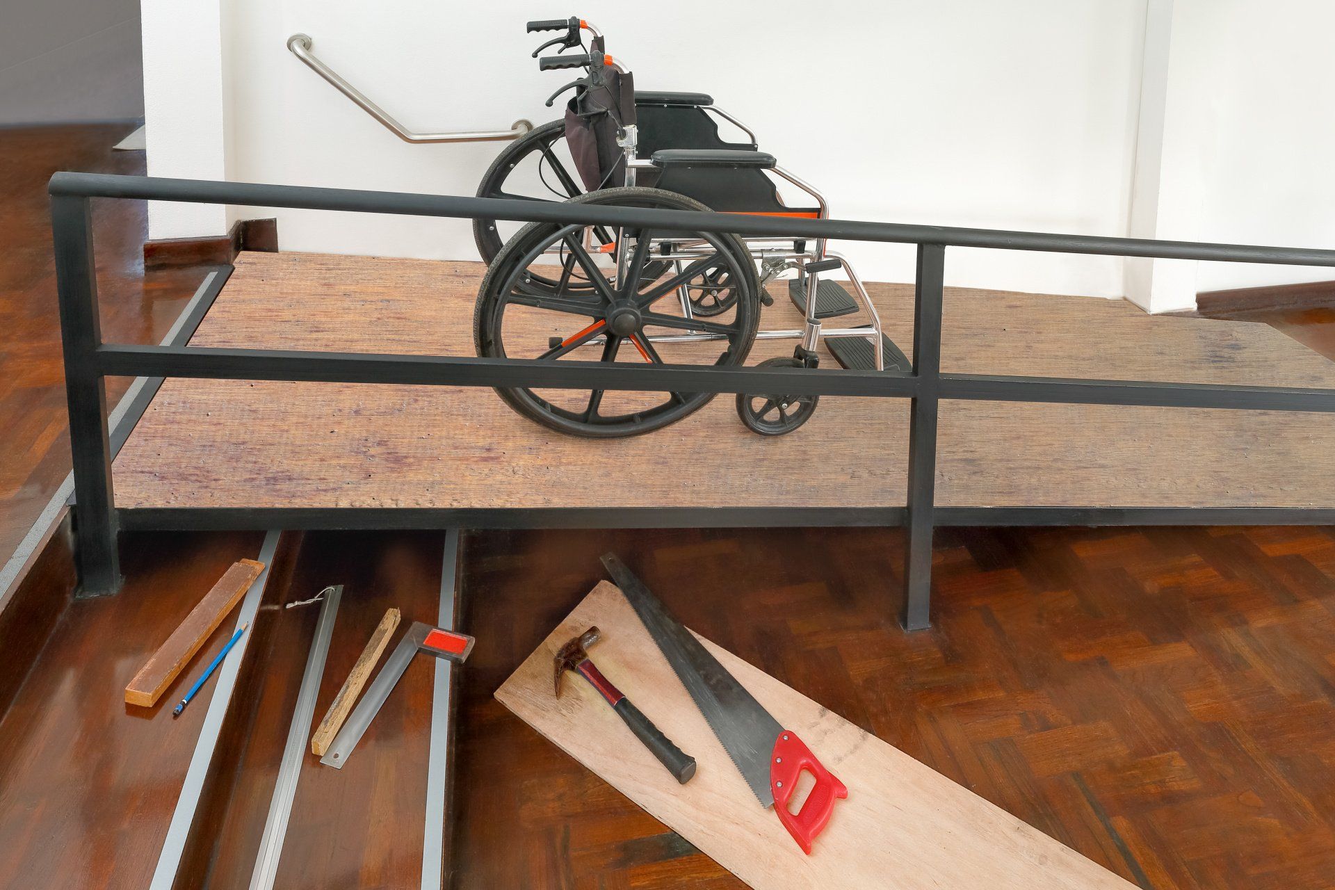 A wheelchair is sitting on a ramp with tools on the floor