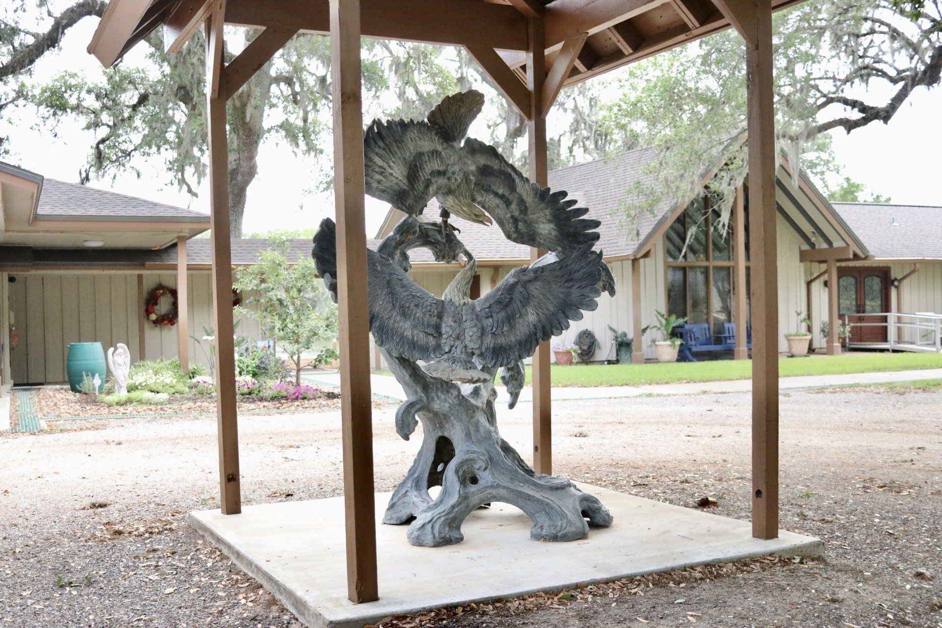 a statue of a dragon is under a gazebo in front of a house