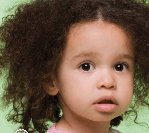 A little girl with curly hair is looking at the camera.