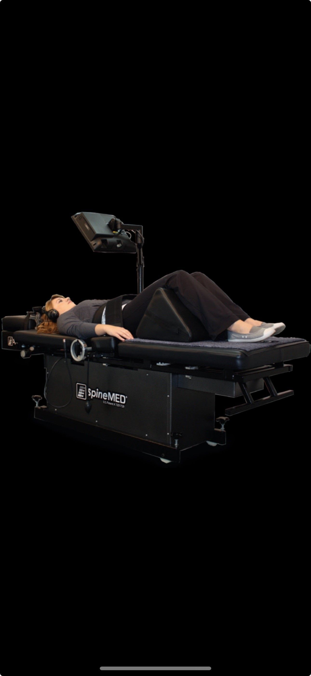 A woman is laying on a stretcher on a black background.