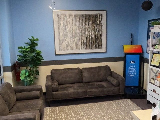 A waiting room with a couch and two chairs