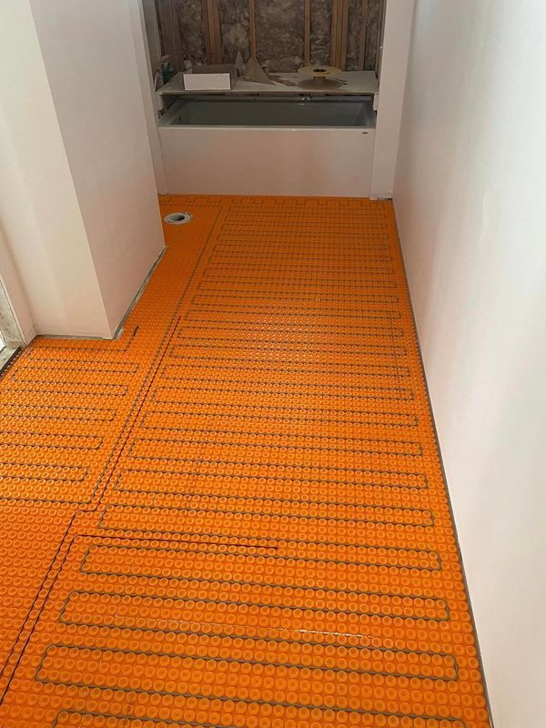 A hallway with an orange floor and a white wall.
