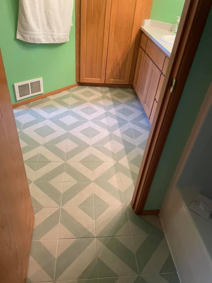 A bathroom with a tiled floor and green walls.
