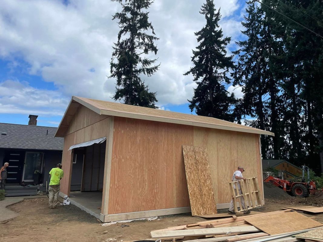 A garage is being built in the backyard of a house.