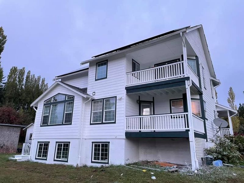 A large white house with a lot of windows and a balcony.