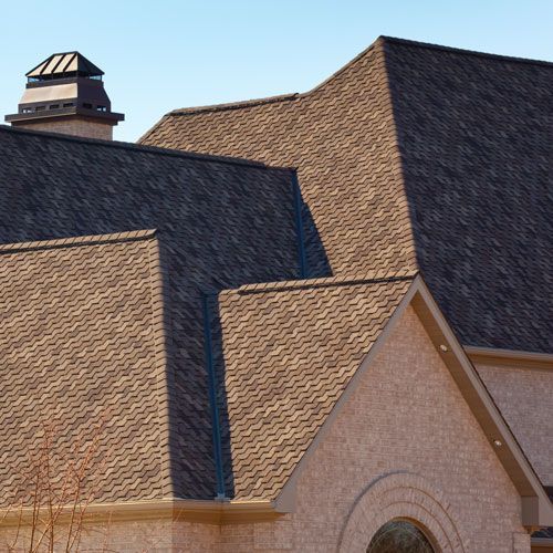 The roof of a house has a chimney on top of it