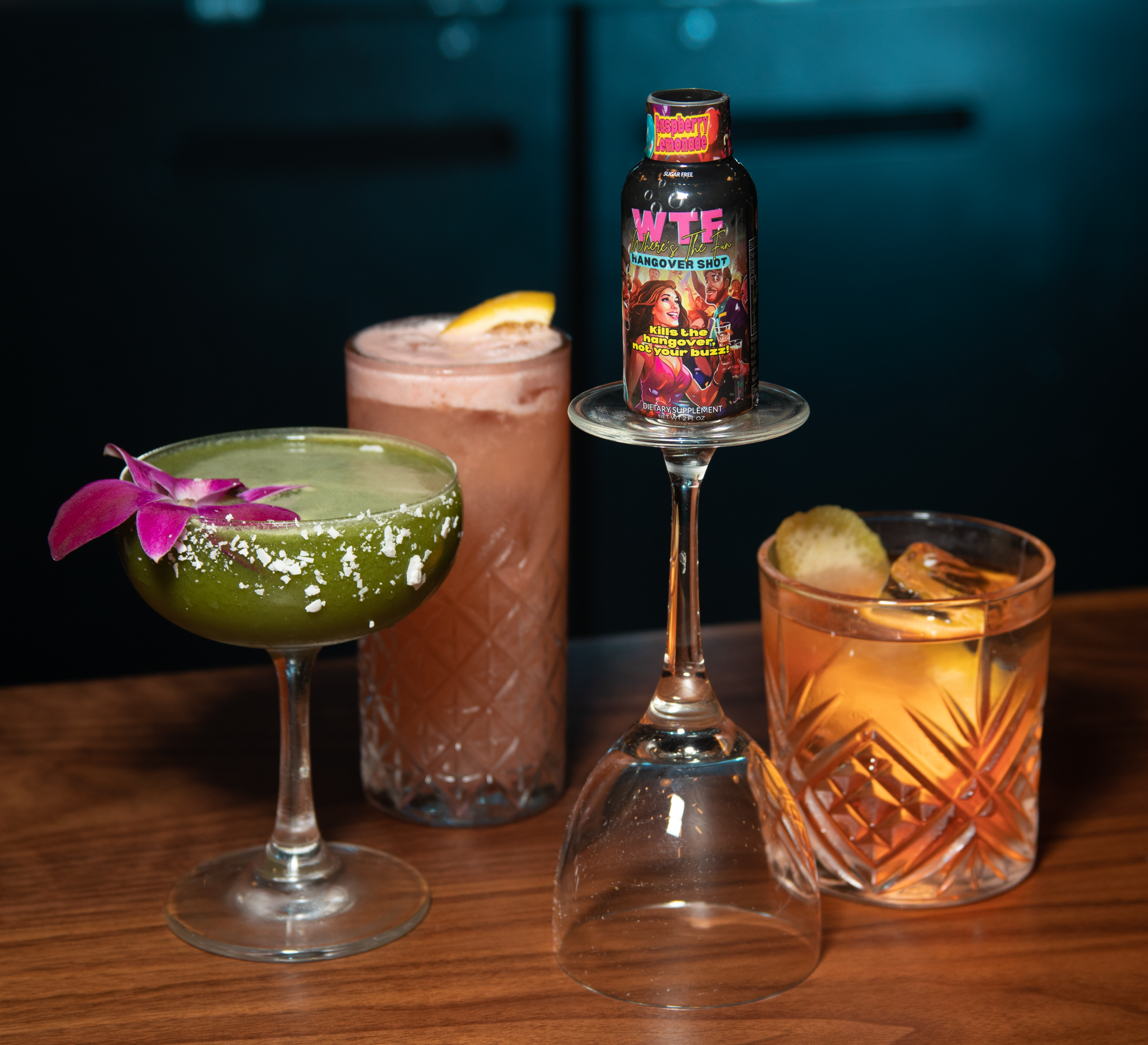 Three cocktails on a wooden surface, one topped with a small 
