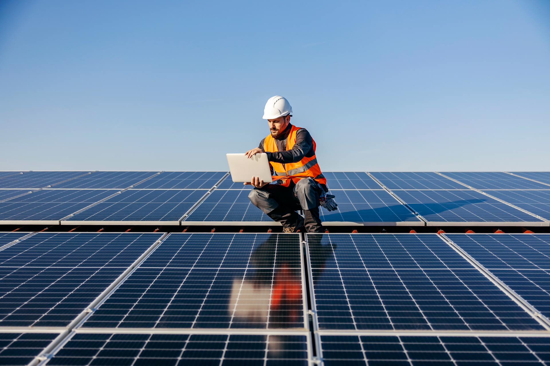 A-worker-on-the-roof-using-laptop-charged-by-sun-energy