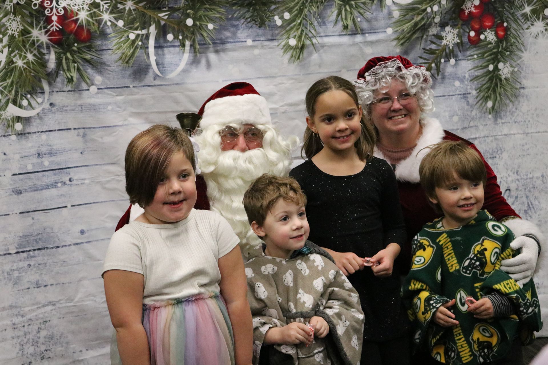 A group of children are posing for a picture with santa claus.