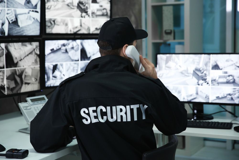 Security guard speaking on the telephone in a surveillance room during monitoring — Alarm Monitoring in Mittagong, NSW
