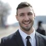 A man in a suit and tie is smiling for the camera.