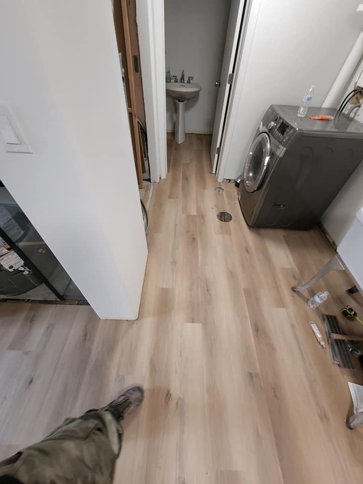 A person is standing in a laundry room with a washer and dryer.