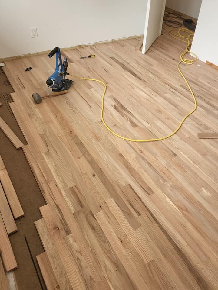 A wooden floor is being installed in a room.