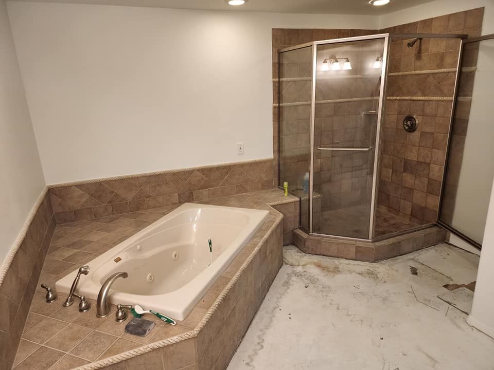 A bathroom with a jacuzzi tub and a walk in shower.