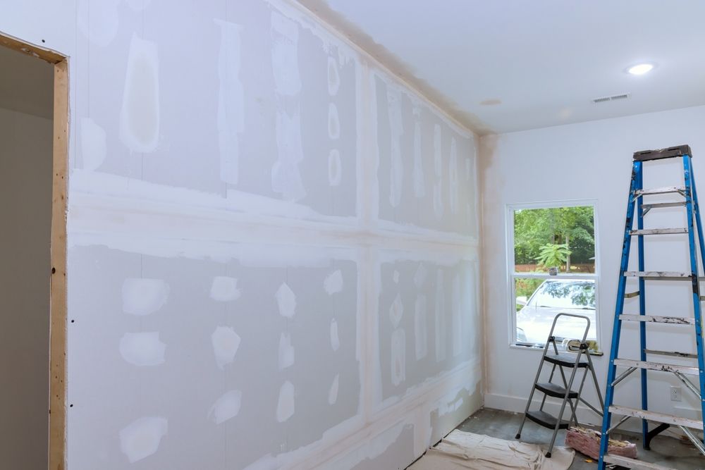 A room is being remodeled with drywall and a ladder.