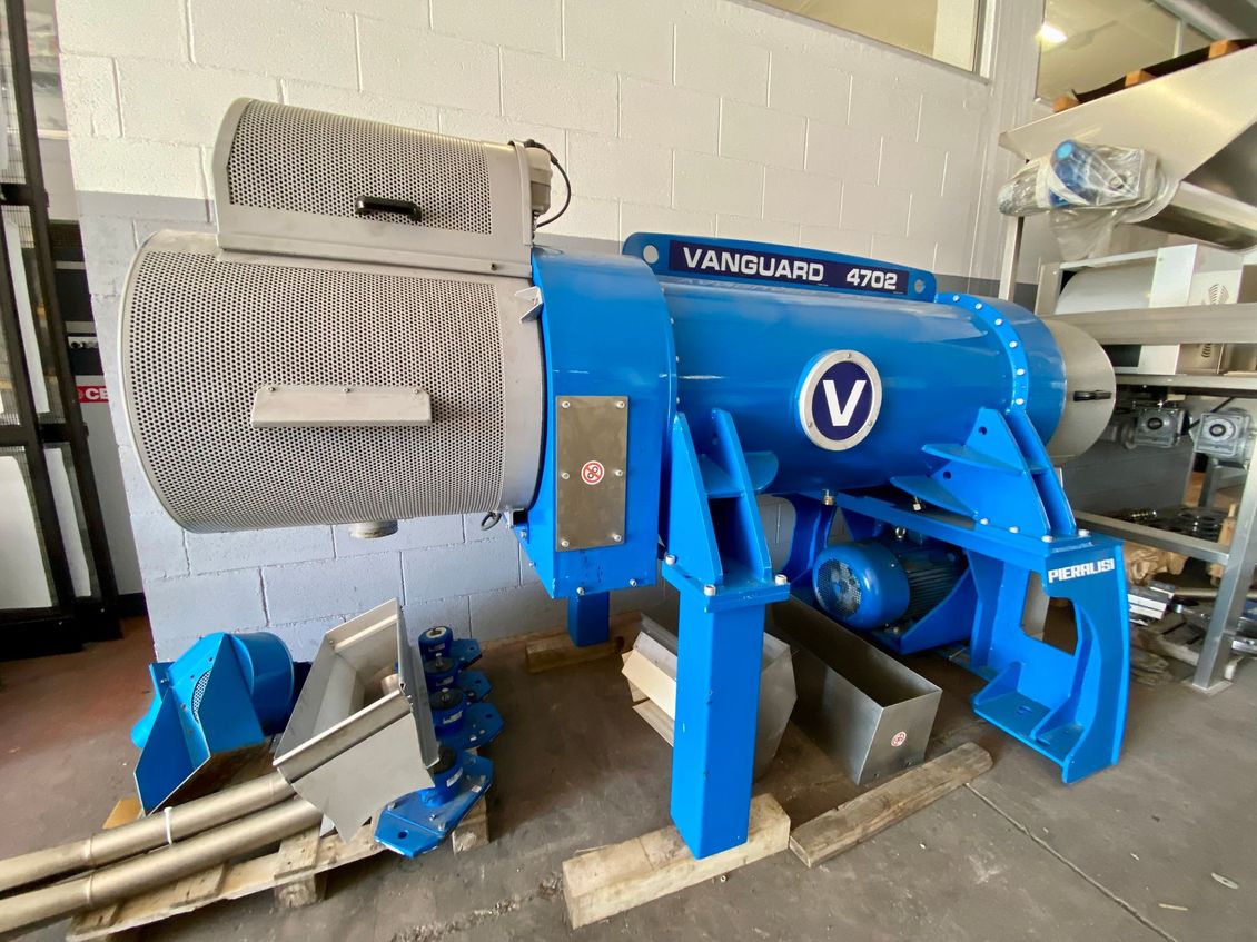 Macchina industriale blu con tubi metallici e motori in un ambiente di fabbrica