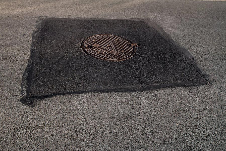 Sewer Cover Patch Repair On Road — Bitumen Services in Darwin, NT