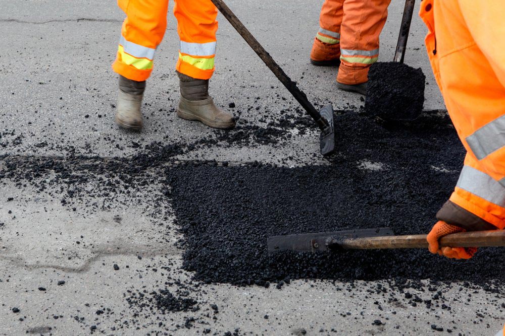 Workers Putting Asphalt On The Pothole Road — Bitumen Services in Darwin, NT