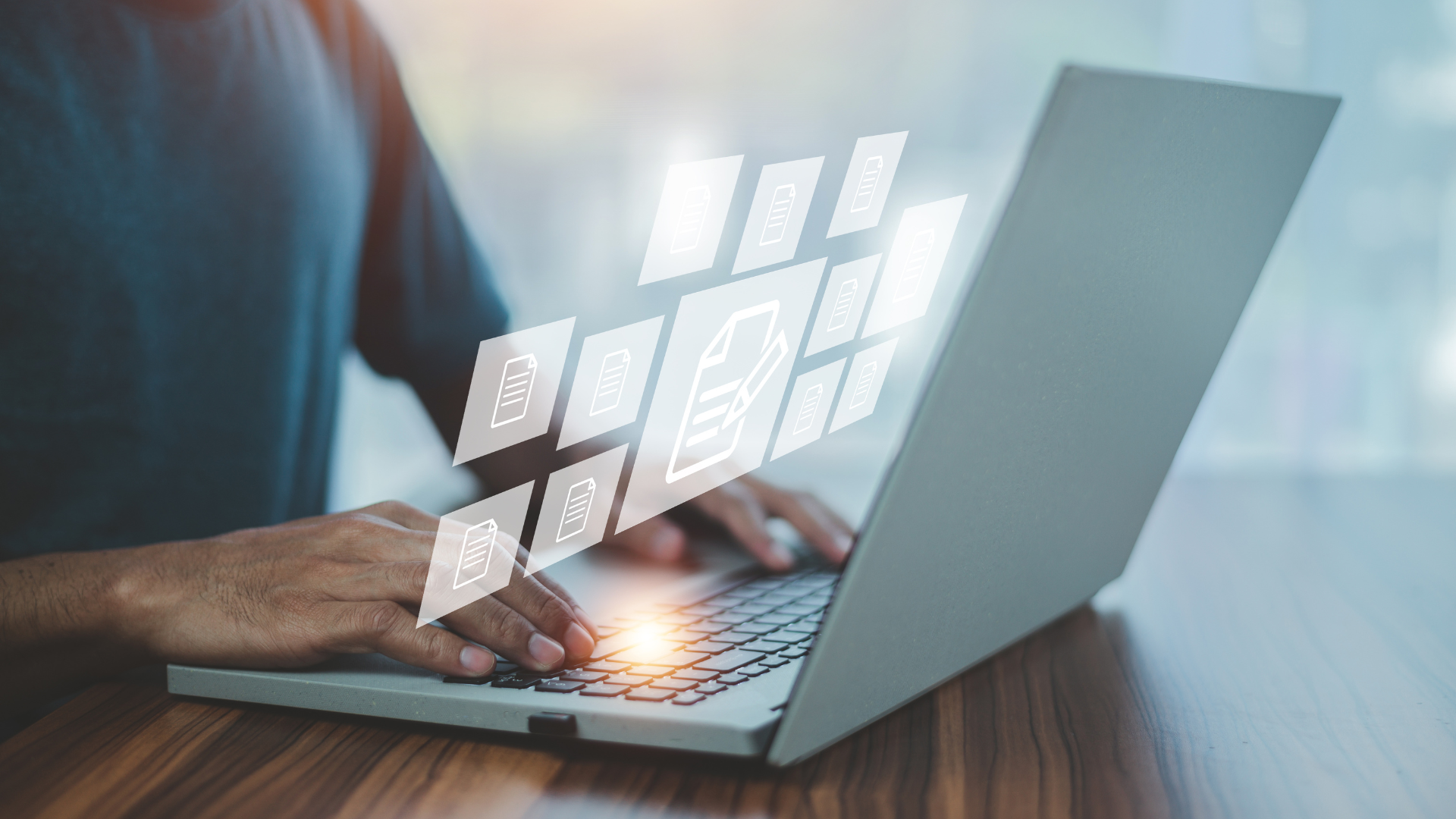 Person typing on laptop with digital document icons floating above.