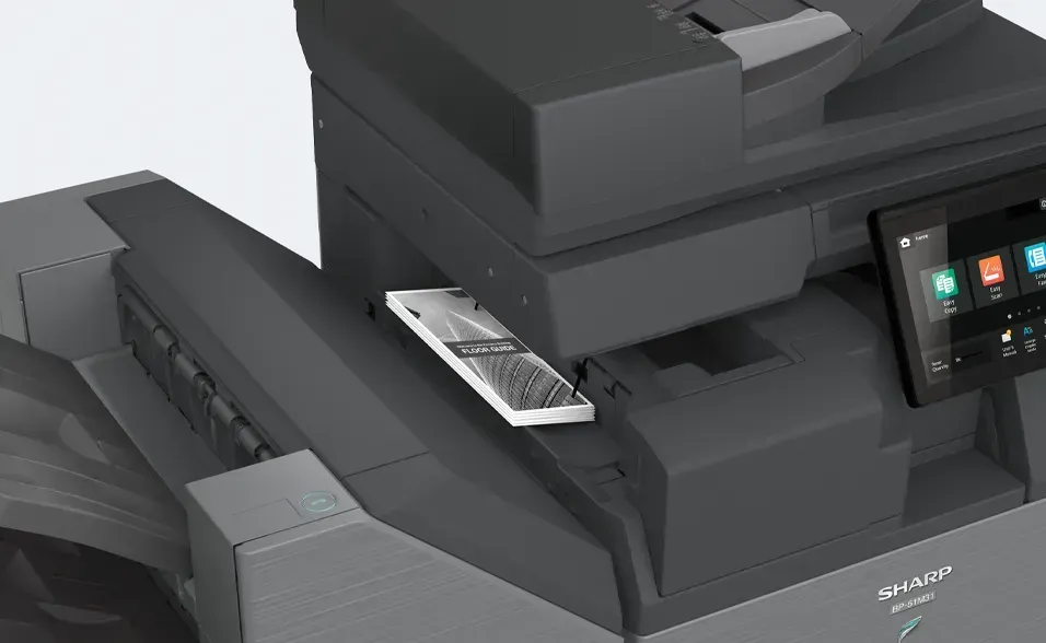 Smartphone resting on a Sharp multifunction printer; black and gray, screen showing interface.